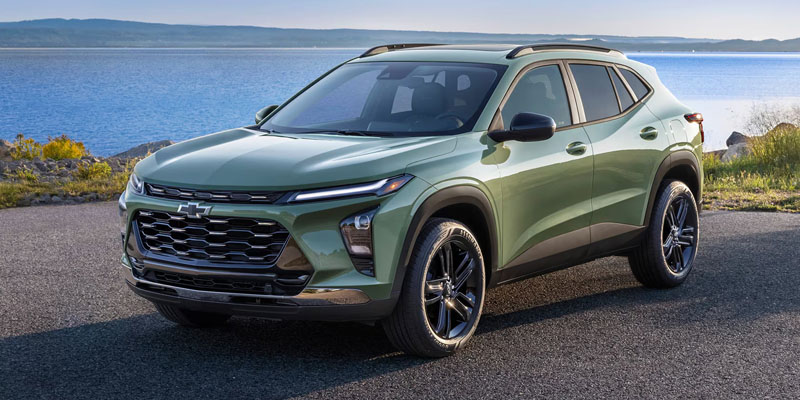 A green Chevrolet Trax SUV parked by a scenic body of water.