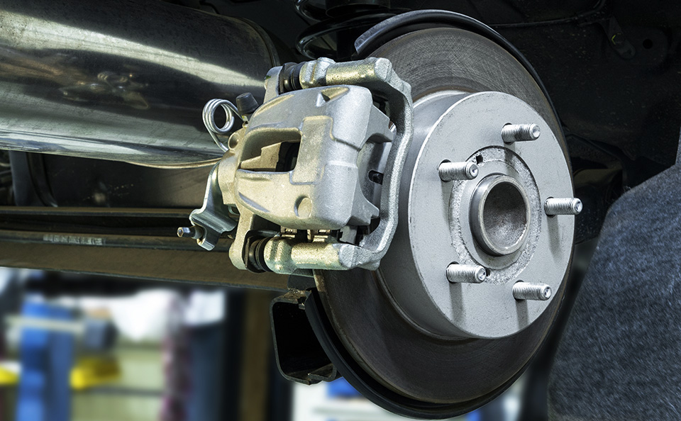 Close-up of a silver disc brake rotor and caliper assembly on a vehicle.