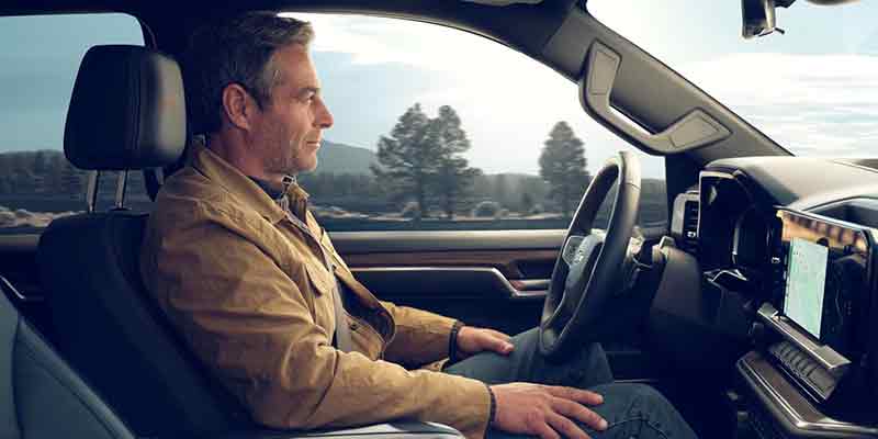 A driver sitting in the driver's seat interior of the 2025 Chevrolet Silverado 1500 in Newton Falls, OH